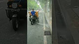 A threewheeled electric scooter sprays the street with highpressure water [upl. by Gabey188]