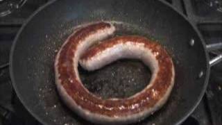 Traditional Cumberland Sausage sizzling in a pan [upl. by Marley]